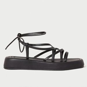 Chunky platform sandal w crisscross straps in black leather. 1.25” platform
